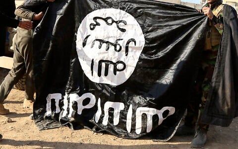 Illustrative: Iraqi Army soldiers celebrate as they hold a flag of the Islamic State group they captured during a military operation to regain control of a village outside Mosul, Iraq, November 29, 2016. (AP Photo/Hadi Mizban, file)