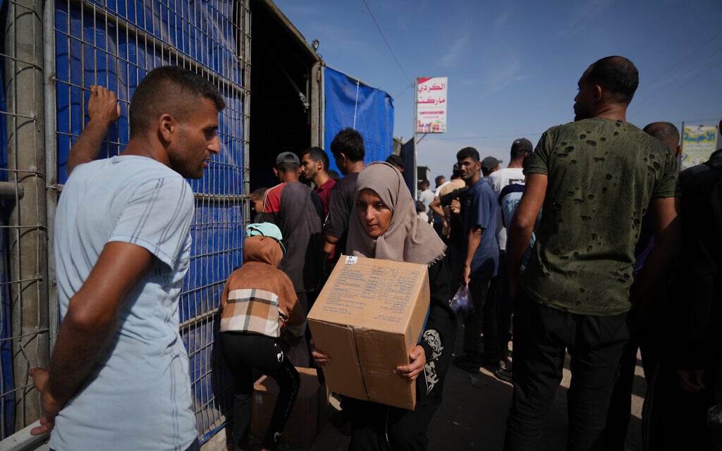 A Palestinian woman carries a box of food from the World Food Program after collecting it in Khan Younis, southern Gaza Strip, November 2, 2025. (AP/Jehad Alshrafi) A Palestinian woman carries a box of food from the World Food Program after collecting it in Khan Younis, southern Gaza Strip, November 2, 2025. (AP/Jehad Alshrafi)