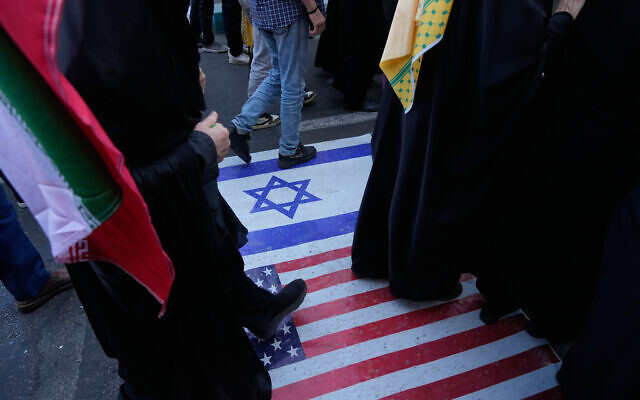 Demonstrators walk on a representation of the US and Israeli flags during an annual rally in front of the former US Embassy in Tehran, celebrating the anniversary of the 1979 takeover of the embassy, Iran, November 4, 2025. (AP Photo/Vahid Salemi) Demonstrators walk on a representation of the US and Israeli flags during an annual rally in front of the former US Embassy in Tehran, celebrating the anniversary of the 1979 takeover of the embassy, Iran, November 4, 2025. (AP Photo/Vahid Salemi)