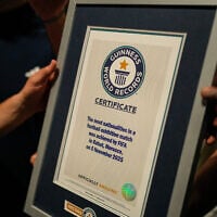Illustrative: People hold a certificate after breaking the Guinness World Record for most nationalities in an exhibition soccer match organized by FIFA, in Rabat, Morocco, November 5, 2025. (AP Photo/Mosa'ab Elshamy)