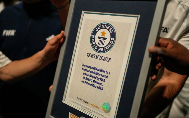 Illustrative: People hold a certificate after breaking the Guinness World Record for most nationalities in an exhibition soccer match organized by FIFA, in Rabat, Morocco, November 5, 2025. (AP Photo/Mosa'ab Elshamy)