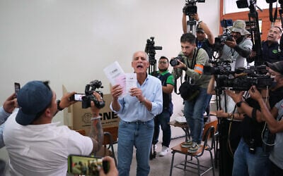 Nasry Asfura, presidential candidate for Honduras' National Party, shows his ballots during general elections in Tegucigalpa, Honduras, November 30, 2025. (AP Photo/Moises Castillo)