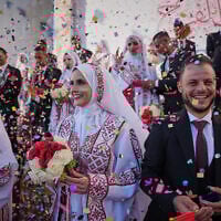 Palestinian couples participate in a mass wedding ceremony in Hamad City in Khan Younis, Gaza Strip, Tuesday, Dec. 2, 2025. (AP Photo/Abdel Kareem Hana)