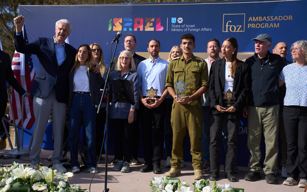 Dr. Mike Evans, founder of the Friends of Zion Heritage Center in Jerusalem stands with freed hostages during a ceremony at the site of the Nova music festival, Dec. 3, 2025. (AP/Ariel Schalit)