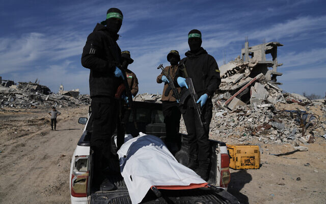 Islamic Jihad and Hamas members carry a white body bag that is believed to be the remains of a deceased hostage, in the town of Beit Lahiya in northern Gaza Strip, Dec. 3, 2025. (AP/Jehad Alshrafi).