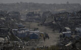 Palestinians walk through the destruction in Gaza City, December 5, 2025. (AP/Abdel Kareem Hana)