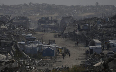 Palestinians walk through the destruction in Gaza City, December 5, 2025. (AP/Abdel Kareem Hana) Palestinians walk through the destruction in Gaza City, December 5, 2025. (AP/Abdel Kareem Hana)