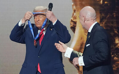 US President Donald Trump, left, is presented with the inaugural FIFA Peace Prize by FIFA President Gianni Infantino during the 2026 FIFA World Cup draw at the Kennedy Center in Washington, December 5, 2025. (AP Photo/Evan Vucci)