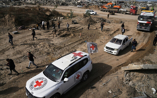 Hamas operatives and Egyptian workers accompanied by members of the International Committee of the Red Cross (ICRC) head to Zeitoun neighborhood of Gaza City to search for the remains of deceased hostages, December 8, 2025. (AP Photo/Jehad Alshrafi)