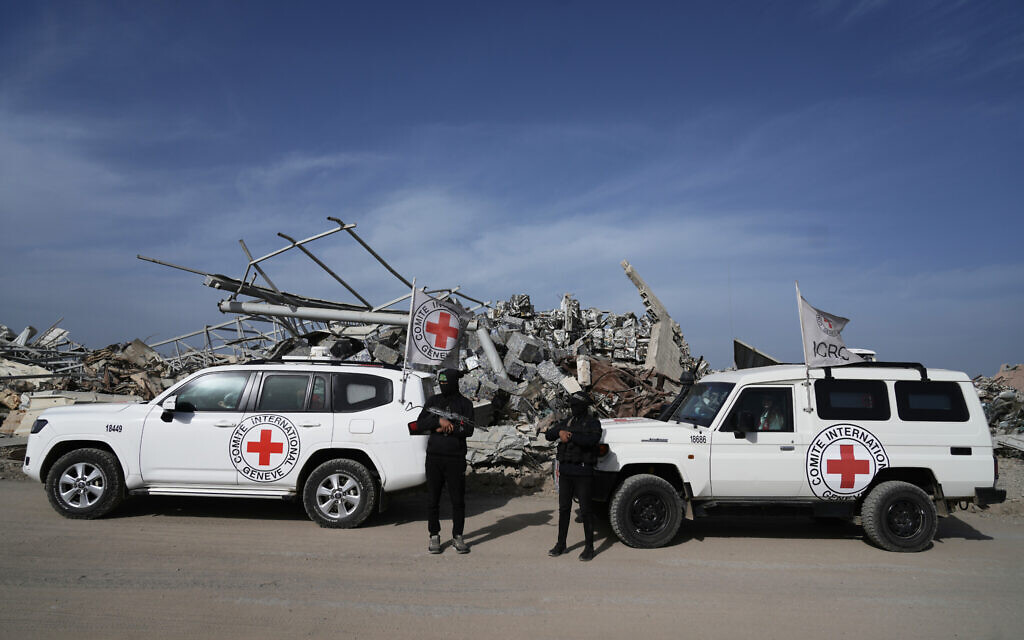 Hamas gunmen accompany members of the International Committee of the Red Cross (ICRC) in the Zeitoun neighborhood of Gaza City to search for the remains of slain hostage Ran Gvili, December 8, 2025. (AP Photo/Jehad Alshrafi)