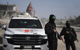 Hamas gunmen accompanied by members of the International Committee of the Red Cross (ICRC) head to the Zeitoun neighborhood of Gaza City to search for the remains of deceased hostages, December 8, 2025. (Jehad Alshrafi/AP)