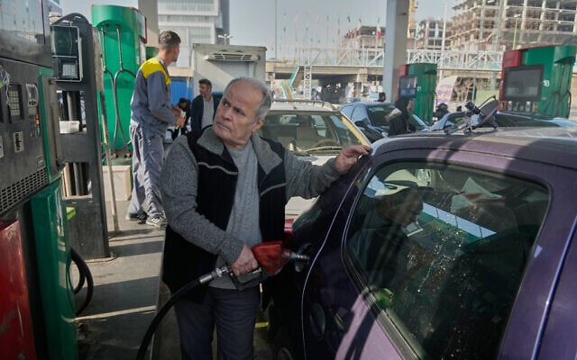 مردی در حال سوخت‌گیری خودروی خود در پمپ بنزینی در تهران، ایران، ۱۳ دسامبر ۲۰۲۵.