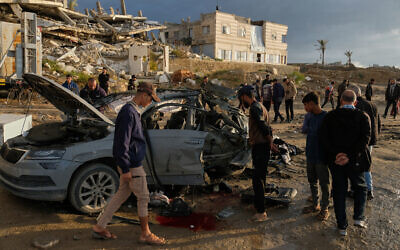 Palestinians look at a destroyed car following an Israeli strike in Gaza City, December 13, 2025, that killed Hamas commander Raed Saad. (AP/Jehad Alshrafi)