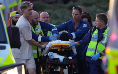 A person on a stretcher after a deadly terror shooting at a Hanukkah event at Bondi Beach in Sydney, December 14, 2025. (AP/Mark Baker) A person on a stretcher after a deadly terror shooting at a Hanukkah event at Bondi Beach in Sydney, December 14, 2025. (AP/Mark Baker)