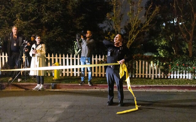 A police officer blocks off a street near Rob Reiner's residence, December 14, 2025, in the Brentwood section of Los Angeles. (AP Photo/Ethan Swope)