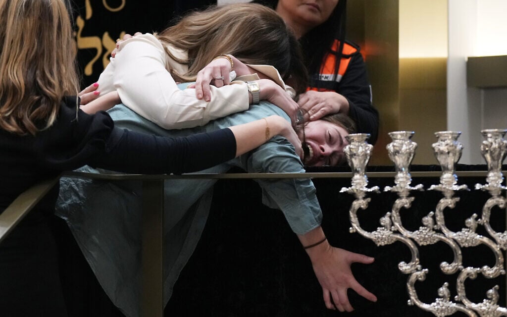 Family members grieve at the coffin of Rabbi Eli Schlanger, a victim in the Bondi Beach mass terror shooting, during his funeral at a synagogue in Bondi on December 17, 2025, in Sydney, Australia. (AP Photo/Mark Baker, Pool)