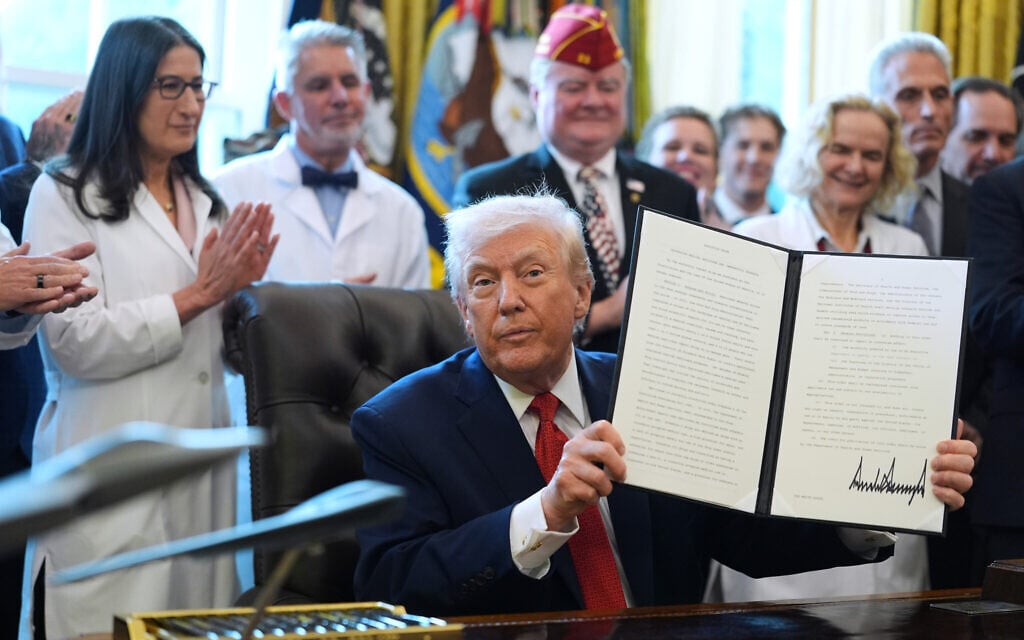 US President Donald Trump displays an executive order reclassifying marijuana as a less dangerous drug in the Oval Office of the White House, Thursday, Dec. 18, 2025, in Washington. (AP Photo/Evan Vucci)