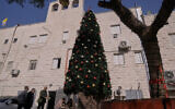 Palestinian parishioners check a recently installed Christmas tree after the previous one was destroyed at the Holy Redeemer Latin Church in the West Bank town of Jenin, December 23, 2025. (Majdi Mohammed/AP)
