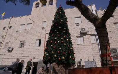 Palestinian parishioners check a recently installed Christmas tree after the previous one was destroyed at the Holy Redeemer Latin Church in the West Bank town of Jenin, December 23, 2025. (Majdi Mohammed/AP)