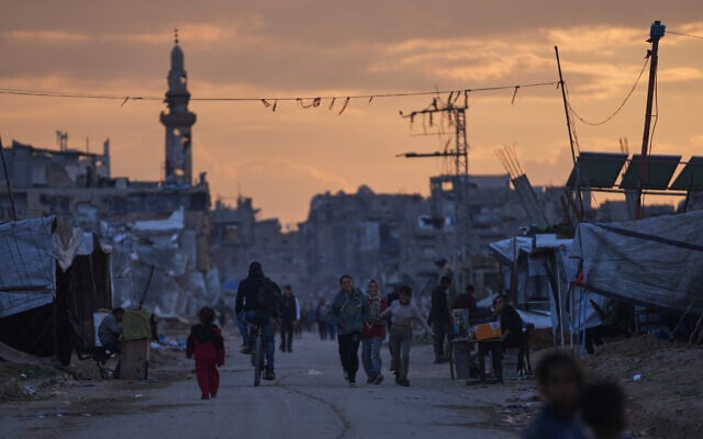 Palestinian youth walk along a tent camp for displaced people as the sun sets in Nuseirat, central Gaza Strip, December 26, 2025. (AP/Abdel Kareem Hana) Palestinian youth walk along a tent camp for displaced people as the sun sets in Nuseirat, central Gaza Strip, December 26, 2025. (AP/Abdel Kareem Hana)