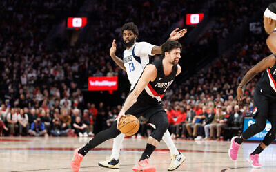 Portland Trail Blazers forward Deni Avdija, middle, drives to the basket against Dallas Mavericks forward Naji Marshall, left, during the second half of an NBA basketball game in Portland, Oregon, December 29, 2025. (Howard Lao/AP)
