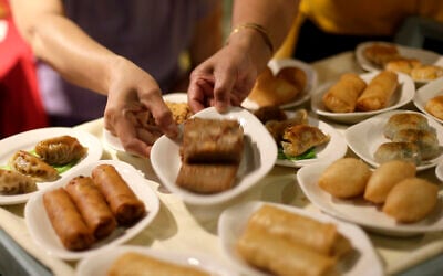 In this photo taken July 5, 2014, a server hands a small plate to a customer from a variety of dishes on a food cart at Bo Lings Chinese restaurant in Kansas City, Missouri. (AP/Charlie Riedel)