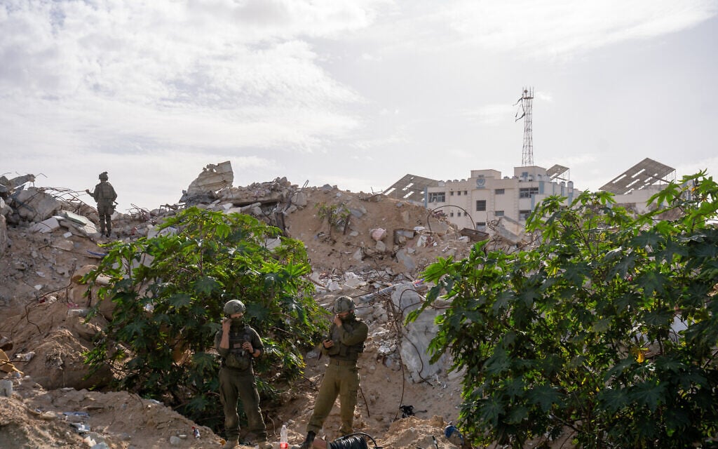 Soldados de las FDI cerca de la entrada de un túnel en la zona de Rafah, al sur de la Franja de Gaza, donde se encontraba el cuerpo del teniente Hadar Goldin. Al fondo se ve un edificio de la UNRWA, 8 de diciembre de 2025. (Emanuel Fabian/Times of Israel)