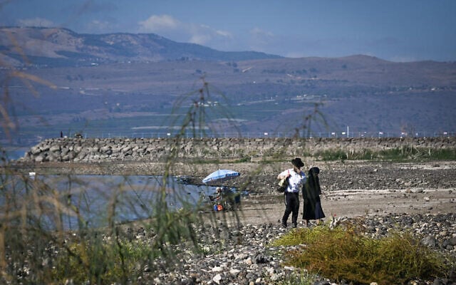 Fishermen enjoy a warm day at a dried-out Sea of Galilee beach in northern Israel, November 26, 2025. (Michael Giladi/Flash90)