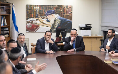 Shas chief MK Aryeh Deri, seated right at head of the table, is seen during a a meeting of the faction at the Knesset in Jerusalem, December 8, 2025. (Chaim Goldberg/Flash90)