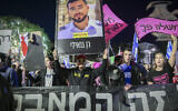 People attend a protest against Prime Minister Benjamin Netanyahu and his government at Habima Square in Tel Aviv on December 13, 2025. One man hoists a photo of Ran Gvili, the last hostage whose body is held by terror groups in Gaza, which purport not to know where it is. (Avshalom Sassoni/Flash90)