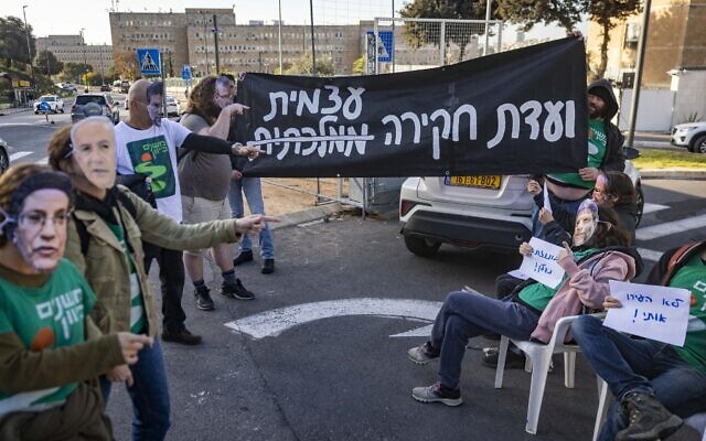Activists calling for the establishment of a state commission of inquiry into Hamas's October 7, 2023, massacre protest outside the Prime Minister’s Office in Jerusalem, December 22, 2025. (Chaim Goldberg/Flash90)
