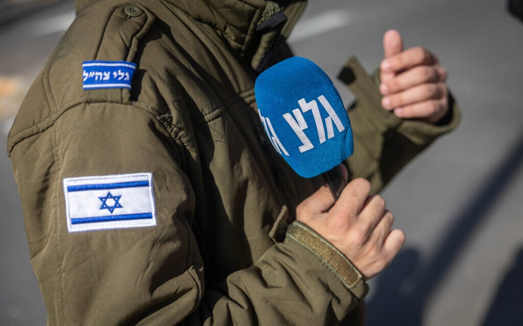 A soldier serving at Army Radio holds a microphone in Jerusalem, December 22, 2025. (Yonatan Sindel/Flash90)