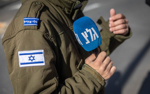 A soldier serving at Army Radio holds a microphone in Jerusalem, December 22, 2025. (Yonatan Sindel/Flash90)