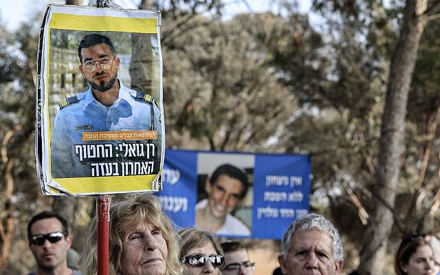 An activist holds up a poster of slain police Master Sgt. Ran Gvili, the last hostage held in Gaza, during a gathering at the Black Arrow Memorial near the Israel–Gaza border, December 26, 2025. (Tsafrir Abayov/ FLASH90)