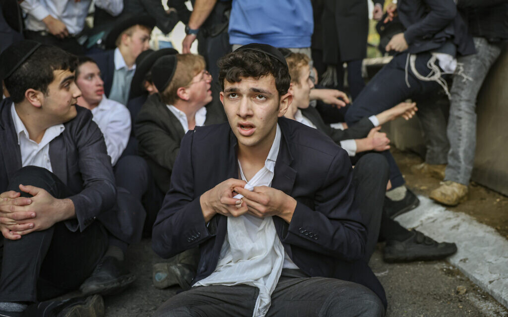 Ultra-Orthodox men seen during a protest blocking Route 4 in opposition to the jailing of yeshiva students who refused to comply with an army conscription order, near Bnei Brak, December 28, 2025. (David Cohen/Flash90)