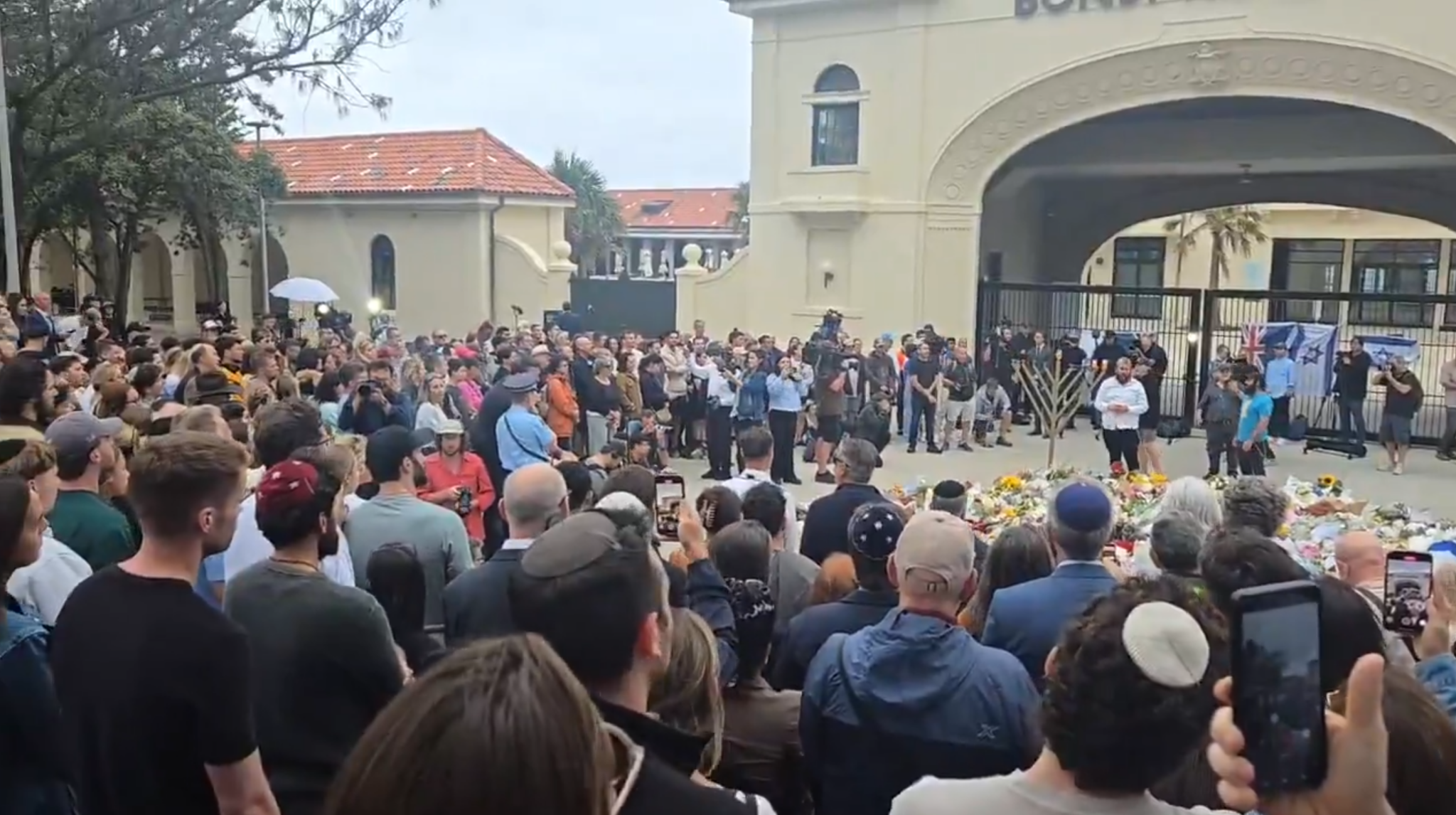 A day after killings, mourners light Hanukkah candles, sing peace prayer at Bondi Beach