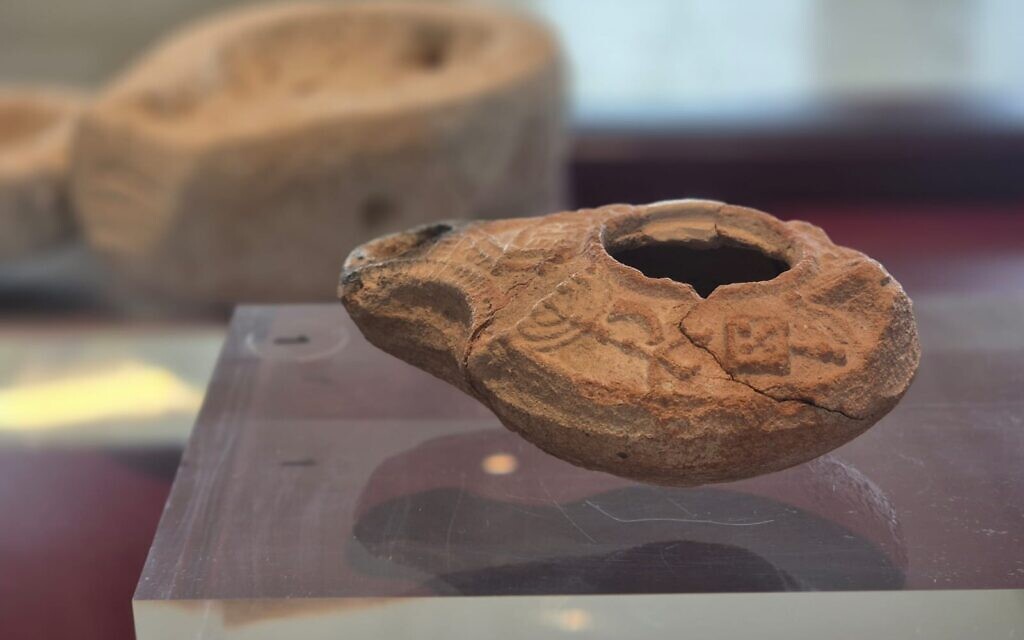 A Samaritan clay lamp from the 3rd–5th centuries CE found in Umm Khaled near Netanya on display at the Jay and Jeanie Schottenstein National Campus for the Archaeology of Israel in Jerusalem. (Yoli Schwartz/Israel Antiquities Authority)