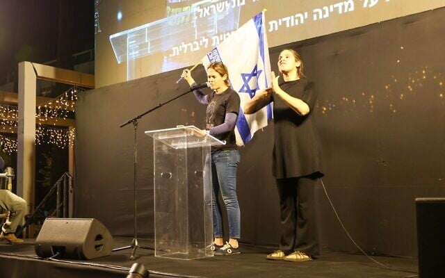 Activist Shikma Bressler waves an Israeli flag at an anti-government rally at Habima Square in Tel Aviv on December 20, 2025. (Gilad Furst/Israeli Pro-Democracy Movement) Activist Shikma Bressler waves an Israeli flag at an anti-government rally at Habima Square in Tel Aviv on December 20, 2025. (Gilad Furst/Israeli Pro-Democracy Movement)