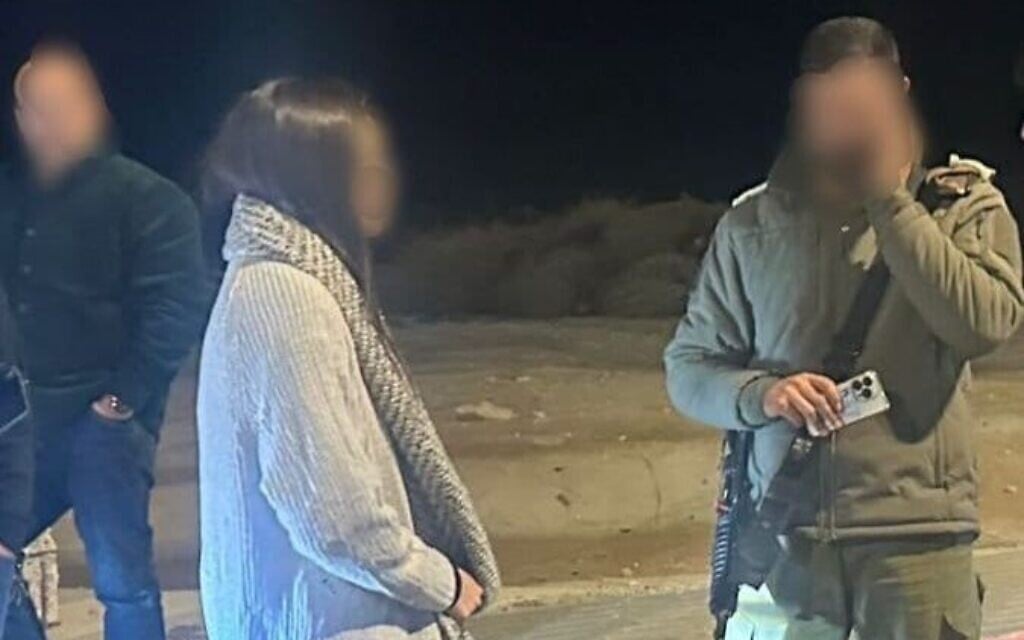 An Israeli woman who was extracted from the West Bank city of Jericho is seen next to an officer from the Civil Administration on December 31, 2025. (Courtesy)