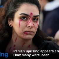 A protester has her face painted to resemble bullet holes during a rally in support of the Iranian people in Rome, January 17, 2026. (AP Photo/Gregorio Borgia)