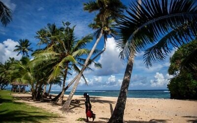 This picture taken on March 23, 2025, shows a resident walking along the Vavau Beach in Samoa on an autumn morning (Manaui FAULALO / AFP)