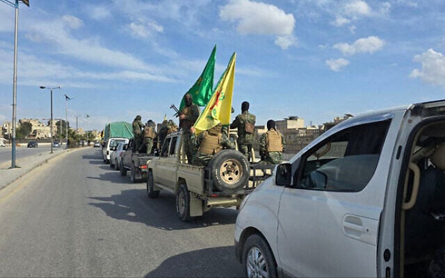 Illustrative: Vehicles carrying Kurdish fighters drive on a road as they leave two neighborhoods in Syria's northern city of Aleppo on April 4, 2025. (SANA / AFP)