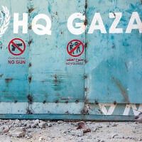 A boy sits outside the entrance to  the United Nations Relief and Works Agency for Palestine Refugees (UNRWA) building&nbsp;complex in Gaza City on September 6, 2025. (Omar AL-QATTAA / AFP)