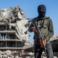 Illustrative: A Hamas operative stands guard as Egyptian workers accompanied by members of the International Committee of the Red Cross (ICRC) use a digger to search for the remains of hostages in the Jabalia refugee camp, in the northern of Gaza Strip, on December 1, 2025. (Omar AL-QATTAA / AFP)