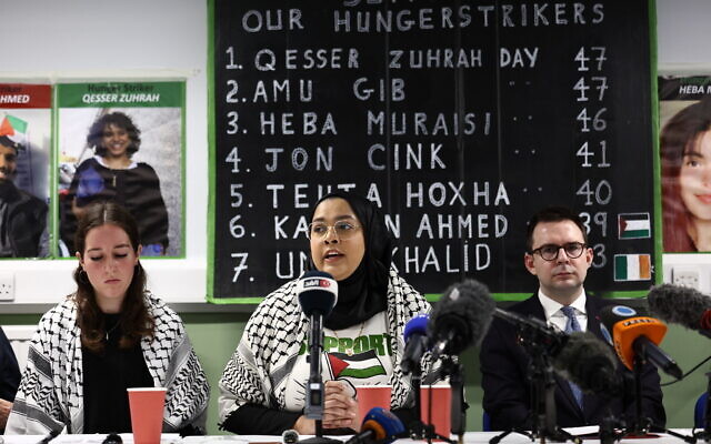 Supporters of hunger-striking prisoners being held on remand charged with offenses related to activism on behalf of Palestine Action hold a press conference calling on the government to intervene and consider their demands in London on December 18, 2025. (HENRY NICHOLLS / AFP)