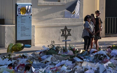 Mourners gather in front of tributes laid in memory of victims of the mass shooting at Bondi Beach, in Sydney on December 20, 2025. (DAVID GRAY / AFP)
