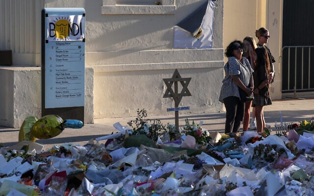 Mourners gather in front of tributes laid in memory of victims of the mass shooting at Bondi Beach, in Sydney on December 20, 2025. (DAVID GRAY / AFP) Mourners gather in front of tributes laid in memory of victims of the mass shooting at Bondi Beach, in Sydney on December 20, 2025. (DAVID GRAY / AFP)