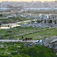 Palestinians make their way through destroyed buildings in the Nuseirat refugee camp in the central Gaza Strip on December 31, 2025. (Eyad Baba / AFP)