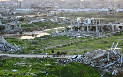 Palestinians make their way through destroyed buildings in the Nuseirat refugee camp in the central Gaza Strip on December 31, 2025. (Eyad Baba / AFP)