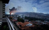 This grab taken on January 3, 2026, from UGC footage released by Jose Abreu on his X account @Jabreu89, shows smoke billowing over Caracas, Venezuela, after a series of explosions during a US military operation that led to the capture of Venezuelan President Nicolas Madruo. (Jose ABREU / @Jabreu89 / X / AFP)